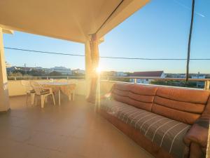 a couch on a balcony with a table and a view at Haus Ljubica Ražanac in Ražanac