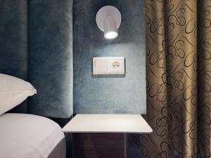 a room with a bed and a table with a light at Hotel The Globe in Amsterdam