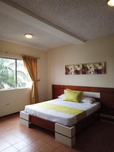 a bedroom with a large bed with a window at Hotel Ebenezer in Santo Domingo de los Colorados