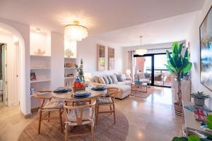 a living room with a table and chairs and a couch at Seaview Apartment - COTO REAL Duquesa in Manilva