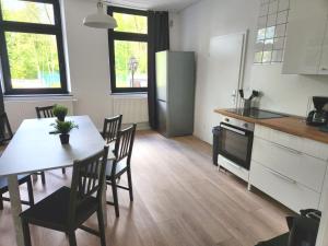 a kitchen with a table and chairs and a refrigerator at ST10-12 Monteurwohnung in Stolberg in Binsfeldhammer +22 photos