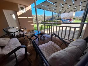 a screened in porch with chairs and a table at Villa Gaga in Međugorje