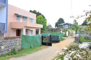 a house with a fence in front of a driveway at Redfox Villa - Kodaikanal in Kodaikānāl