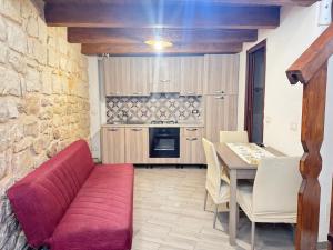 a living room with a red couch and a table at B&B Mairè in Scicli +10 photos