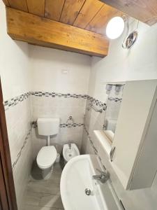 a bathroom with a white toilet and a sink at B&B Mairè in Scicli