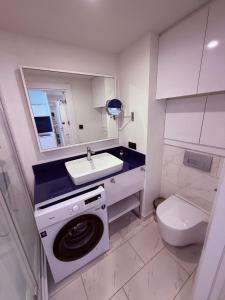 a bathroom with a washing machine and a sink at Sun Set Apartments in Batumi +53 photos