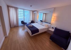 a bedroom with a bed and a chair and a mirror at Sun Set Apartments in Batumi