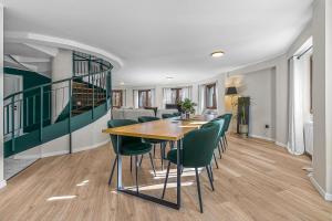 a dining room with a table and green chairs at Villa Octogon Câmpina in Câmpina