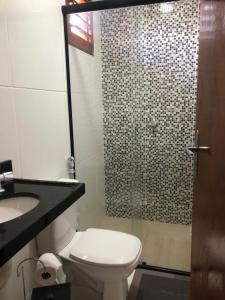 a bathroom with a toilet and a sink and a shower at Pousada casa sonho do mar in Fortim +15 photos