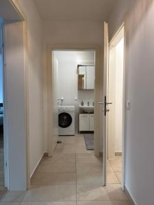 a hallway leading to a bathroom with a washing machine at QuietApt Vienna in Vienna