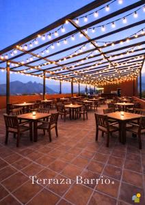 eine Terrasse mit Tischen, Stühlen und Lichtern in der Unterkunft Hotel Barrio Boutique in Monterrey