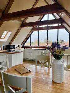 a kitchen with a table with a vase of flowers on it at White House Lodges in Heveningham