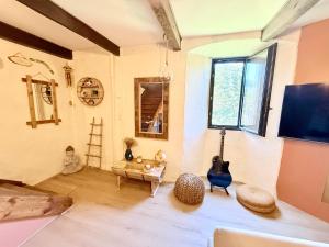 a living room with a guitar and a table at La Grange de Bosc -Ardèche verte - Proche train de Lamastre in Saint-Prix