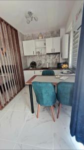 a kitchen with a table and two blue chairs at Raul Studio in Saturn