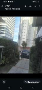 a view of a park with a bench and buildings at Pacor in Mar del Plata