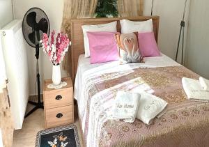 a bedroom with a bed with pink pillows and a fan at Elias Home in Volos