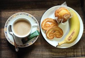 a plate of food with a cup of coffee and a banana at Raco del Tosca in Beceite