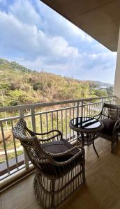 two chairs and a table on a balcony with a view at Nade Suites - Pico De Loro MIB 601 in Nasugbu