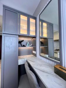 a dining room with a table and a large mirror at Four Living Sky House BSD in Samporo