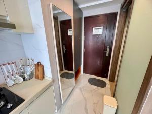 a bathroom with a wooden door and a mirror at Four Living Sky House BSD in Samporo