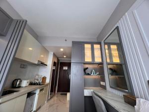 a kitchen with a large mirror and a room at Four Living Sky House BSD in Samporo