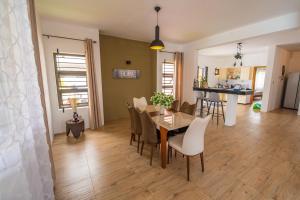 a dining room and living room with a table and chairs at Villa Le Mahé, Mahébourg in Mahébourg
