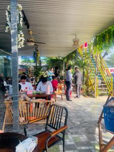 a group of people sitting at tables in a restaurant at Ruby Hotel in Nhơn Trạch