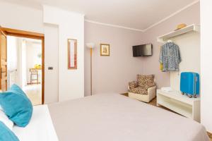 a bedroom with a white bed and a chair at Il Giardino dei Gigli in Meta