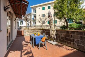 a table with chairs and an umbrella on a patio at Il Giardino dei Gigli in Meta