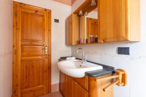 a bathroom with a sink and a wooden door at Il Giardino dei Gigli in Meta +56 photos