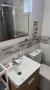 a bathroom with a sink and a toilet and a mirror at 7 Calcosas in Valverde