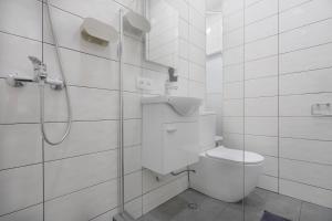 a white bathroom with a toilet and a shower at Avgarose in Itʼkhvisi