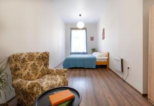 a living room with a chair and a bed at Avgarose in Itʼkhvisi