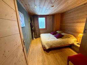 a bedroom with a bed in a wooden room at Edenblanc in Arâches-la-Frasse