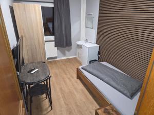 a small room with a bed and a small table at Pension Raunheim in Raunheim +16 photos
