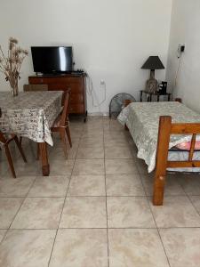 a room with two beds and a table and a tv at Casa 2 Habitaciones in Las Varillas