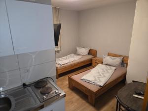 a small room with two beds and a stove at Pension Raunheim in Raunheim