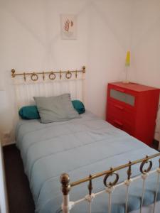 a bedroom with a bed and a red dresser at Studio Barbotan-les-Thermes in Cazaubon