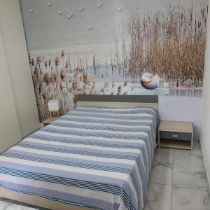 ein Schlafzimmer mit einem Bett und einem Gemälde an der Wand in der Unterkunft forgestudio in Saint-Bômer-les-Forges