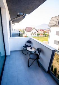 a patio with two chairs and a table on a balcony at Piatra Studio in Piatra Neamţ