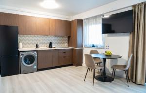 a kitchen with a washing machine and a table with chairs at Piatra Studio in Piatra Neamţ