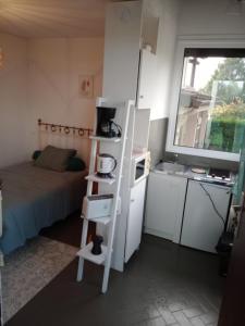 a small room with a bed and a white refrigerator at Studio Barbotan-les-Thermes in Cazaubon