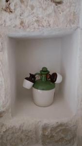 a small green and white pot on a wall at Casetta Wetto' in Monopoli