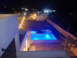 a swimming pool at night with a house at Villa Franet in Watamu