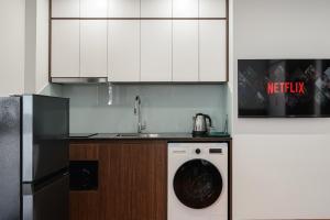 a kitchen with white cabinets and a washing machine at Luxe Paradise Suites - No34 Alley 260 Đội Cấn in Hanoi +49 photos