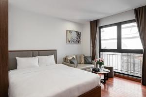 a hotel room with a bed and a large window at Luxe Paradise Suites - No34 Alley 260 Đội Cấn in Hanoi