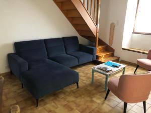 a living room with a blue couch and a table at Gîte Le Colombet in Audrix