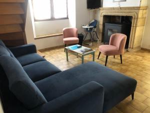 a living room with a blue couch and two chairs at Gîte Le Colombet in Audrix