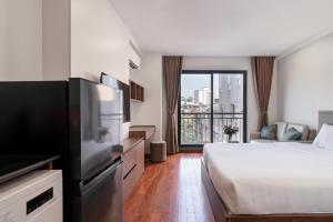a hotel room with a bed and a television at Luxe Paradise Suites - No34 Alley 260 Đội Cấn in Hanoi