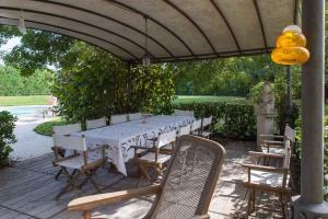 a white table and chairs under an umbrella at Casa Cardinala in Gambellaro